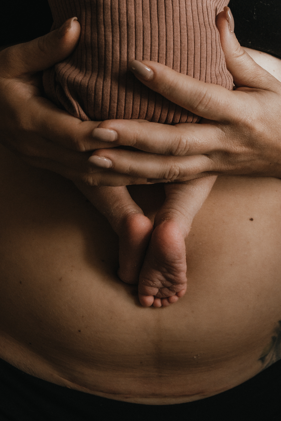 Kaiserschnittsnarbe im Detail mit kuschendem Neugeborenen auf dem Bauch der Mutter beim Neugeborenenshooting in Boxberg/O.L.